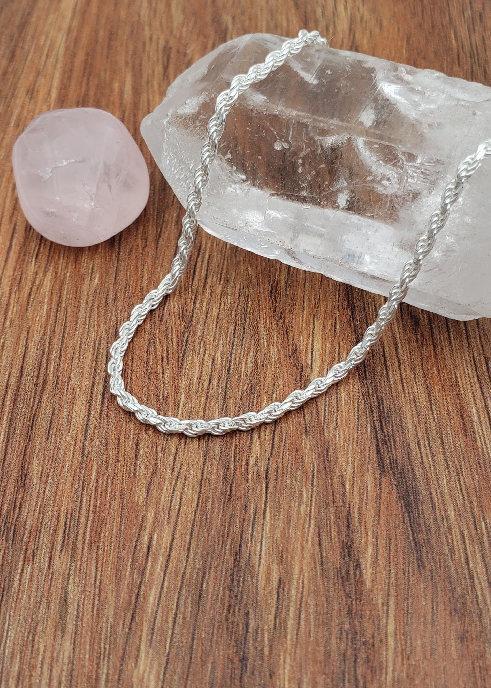 A chain necklace artfully draped over a crystal