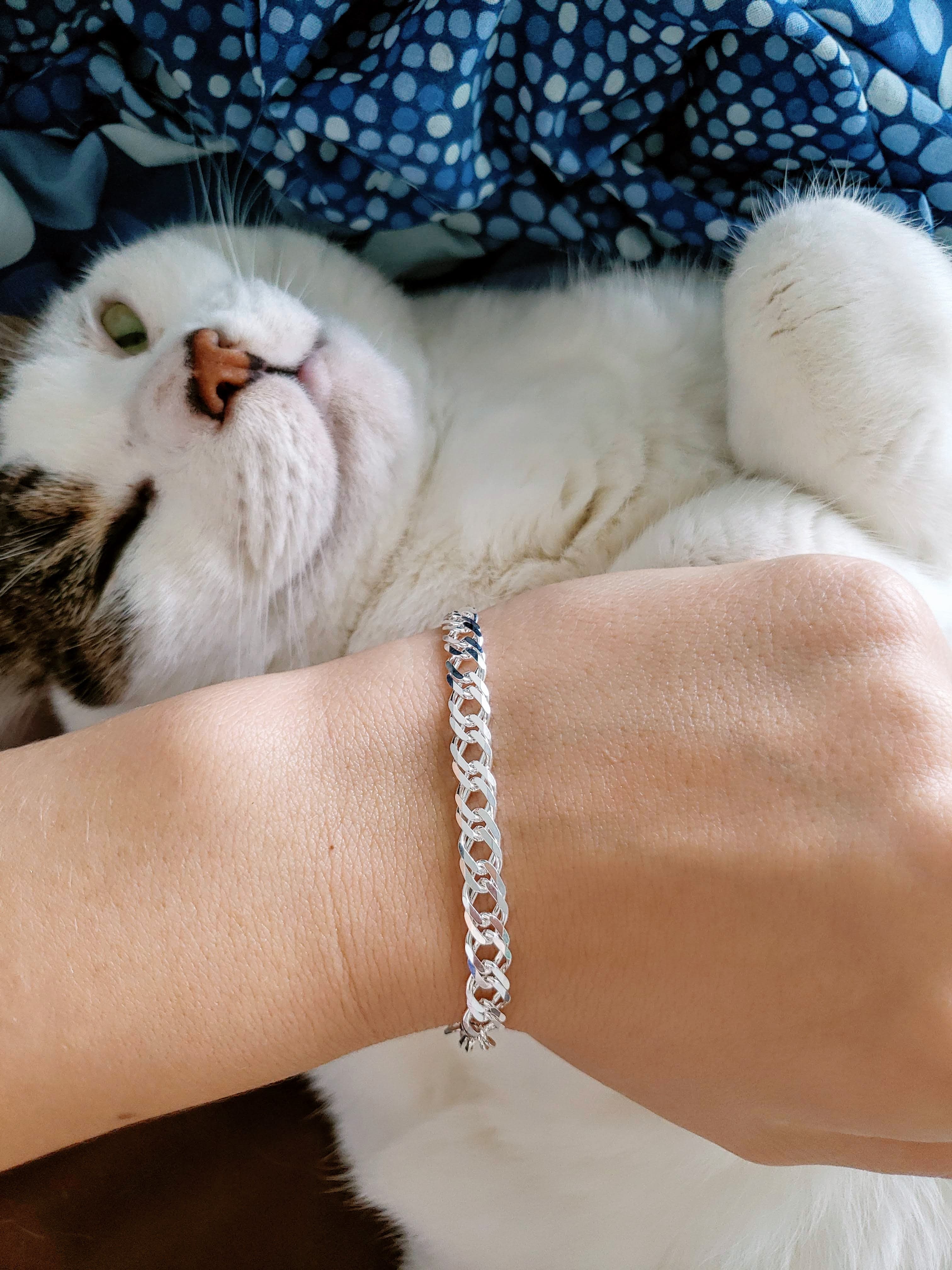 A bracelet being worn, with a fat cat in the background